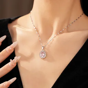 Close-up of silver-tone necklace with an oval pink zircon pendant on a woman's elegant neck