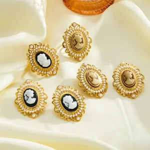 Close-up of vintage cameo rings with white pearls and gold stainless steel details