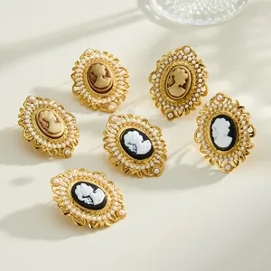Detail shot of vintage oval cameo earrings and rings with elegant pearls and gold plating