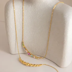 Detail view of 18K gold stainless steel necklaces with colorful zircon circular pendants.
