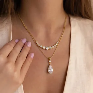Close-up of 18K gold stainless steel layered necklace with pear-shaped zircon pendant.