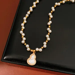 Macro view of hulu gourd pendant with mother of pearl on a delicate pearl beaded chain