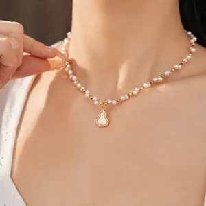 Close-up of a gold-plated pearl necklace with a zirconia-set mother of pearl gourd pendant