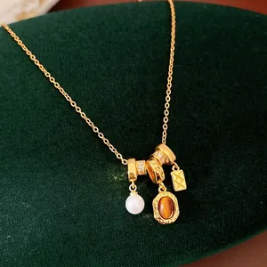 Élégant collier rétro en or avec perle et pendentif ambre ovale sur velours vert