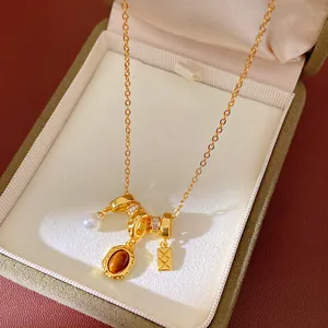 Gros plan d'un collier vintage doré avec pendentifs en perle et œil de tigre