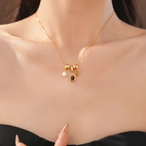 Vue détaillée du collier élégant avec pierre ovale et perles sur un modèle féminin