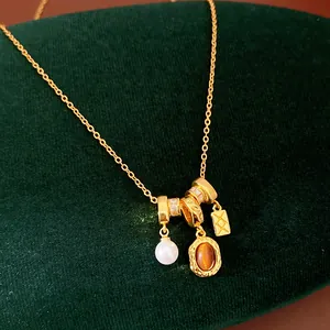 Vue détaillée d'un collier vintage doré avec des breloques en perles et pierres ambrées