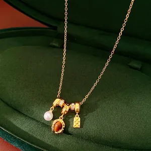 Gros plan détaillé d'un collier en or vintage avec perle et pierres ovales brunes