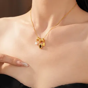 Vue rapprochée d'un collier vintage doré avec perle et pierre marron sur un modèle