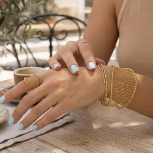 Lifestyle view of gold-plated stainless steel wire mesh ring and matching bracelet set
