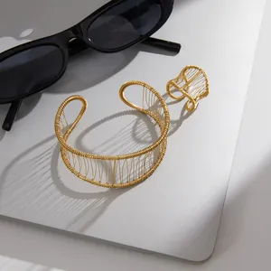 Detail view of gold wire mesh bracelet and ring set on lifestyle background