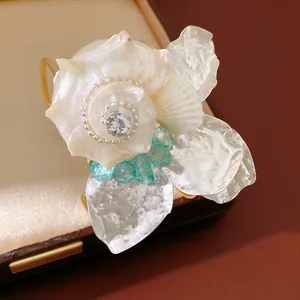 Primer plano exquisito de una pulsera de concha hecha a mano con diamantes de imitación y piedras