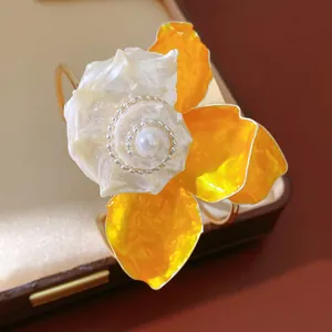 Primer plano detallado del centro de nácar y perla de un brazalete de flores amarillas