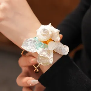 Primer plano de una pulsera de flores de concha de lujo con diamantes e turquesa