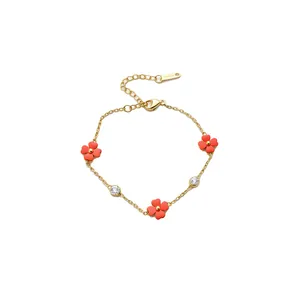 Elegante pulsera dorada con flores de trébol rojas y brillantes piedras de circonia