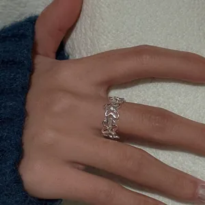Detailed close-up showing the intricate hollow flower pattern of this silver zircon ring