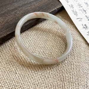 Dettaglio di un elegante bracciale in calcedonia circolare con venature rosse.