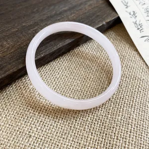 Dettaglio macro di un bracciale a cerchio in calcedonia rosa pallido traslucida