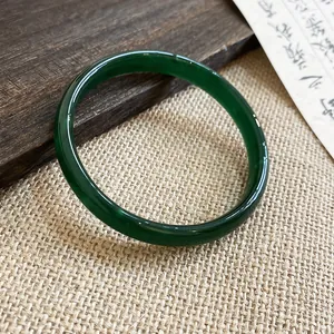 Primo piano di un bracciale in calcedonio verde scuro con trama traslucida e liscia