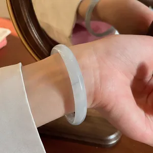 Dettaglio di un elegante bracciale in calcedonia grigio chiaro indossato al polso
