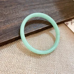Primo piano di un elegante bracciale in calcedonio verde chiaro con finitura circolare.