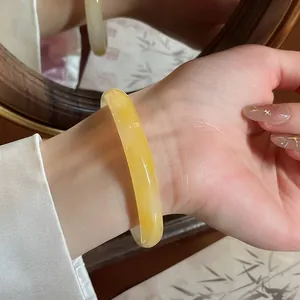 Vista dettagliata di un elegante bracciale in calcedonio giallo al polso, luce calda
