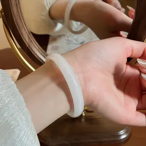 Primo piano di un bracciale rigido in calcedonio bianco al polso