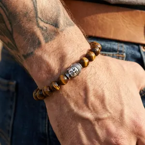 Close-up of tiger eye stone beads and silver Buddha head on a vintage men's bracelet