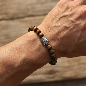 Detailed view of tiger eye stone beads and a retro silver Buddha head on a beaded bracelet