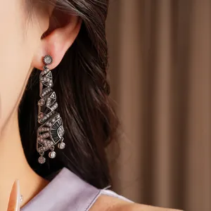 Primo piano di orecchini a spirale in argento con zirconi neri indossati da una modella
