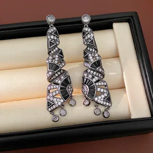 Dettaglio degli orecchini pendenti a spirale in zircone bianco e nero in portagioie.