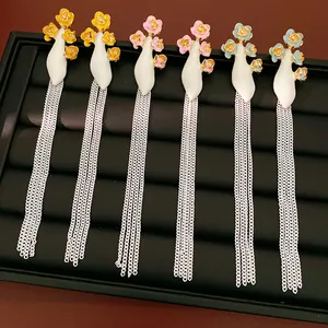Vue détaillée de boucles d'oreilles fleurs en émail vintage avec de longues chaînes à glands