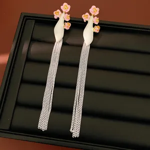 Vue détaillée de boucles d'oreilles vintage avec fleurs en émail rose et longs glands en argent