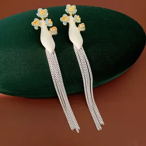Gros plan de boucles d'oreilles fleurs vintage sur un support en velours vert foncé