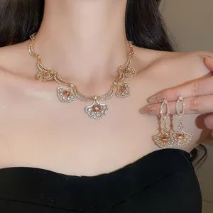 Close-up of luxury diamond-studded fan-shaped pendant necklace and earrings set
