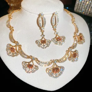 Detailed view of elegant gold-toned fan-shaped necklace and earring set with crystals.