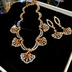 Macro view of fan-shaped jewelry set with amber stones and crystals in box.