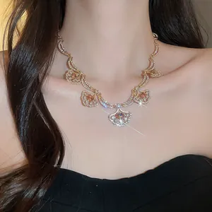 Detailed view of a gold-plated fan-shaped pendant necklace with sparkling crystals.