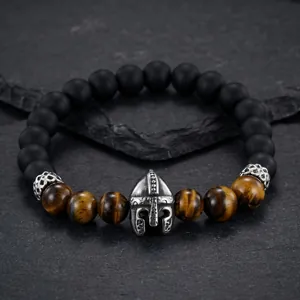 Detailed view of Spartan helmet charm on tiger eye and matte onyx beaded bracelet