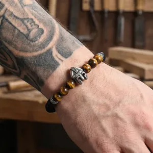 Detail view of Spartan helmet tiger eye and onyx beaded bracelet on tattooed arm