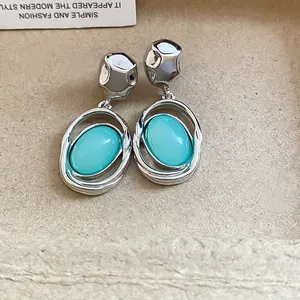 Detailed view of elegant silver oval stud earrings with turquoise acrylic pendants