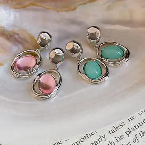 Close-up detail of elegant oval acrylic pendant earrings with hammered silver studs