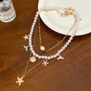 Detailed macro view of a multi-layer pearl necklace with starfish and fishtail charms