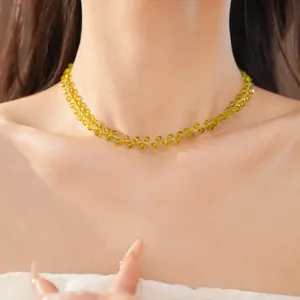 Detail shot of yellow faceted glass bead choker with gold plated links on neck