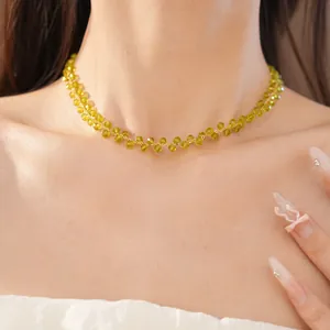 Close-up detail of a 14k gold plated beaded necklace with olive green glass beads.
