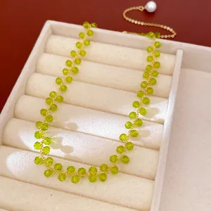 Detail view of lime green glass bead necklace with 14k gold plating and pearl charm