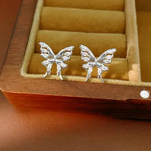 Dettaglio di orecchini a farfalla in argento con zirconi in una scatola portagioie elegante