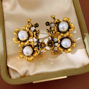Detailed macro shot of vintage flower earrings with pearls and crystals in a velvet box