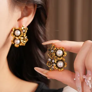 Detailed macro view of vintage gold floral earrings with pearls and crystals on ear