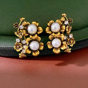 Detailed view of vintage gold-toned floral earrings with lustrous pearls and rhinestones